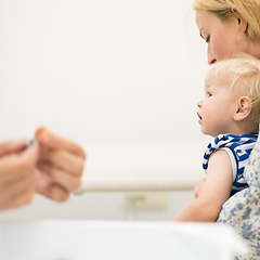 Image showing Child beeing vaccinated by pediatrician in presence of his mother. Preventive vaccination against Diphtheria, whooping cough, tetanus, hepatitis, haemophilus influenzae, pneumococcus, poliomyelitis