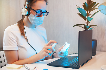 Image showing Woman disinfects the surface of the phone