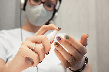 Image showing Woman disinfects the surface of the phone