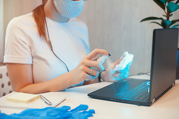 Image showing Woman disinfects the surface of the phone