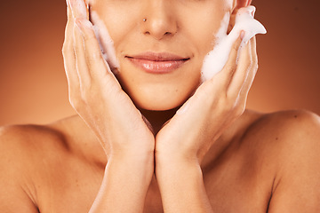 Image showing Woman, face and hands with soap skincare for a cometics beauty routine, natural body and liquid cleaning wellness. Sustainable cosmetic health, washing skin clean and smile on a brown wall background