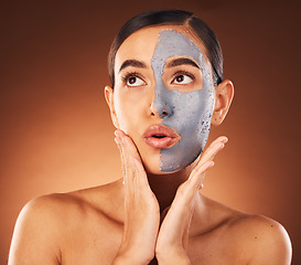 Image showing Woman, clay face mask and beauty, facial and expression, dermatology and studio background. Thinking model, charcoal cosmetics and glowing skincare, shine and aesthetic transformation for acne