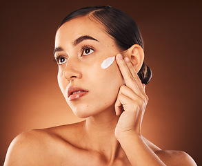 Image showing Skincare, face and woman with beauty cream product for healthy facial grooming or glowing skin in studio background. Cosmetics, dermatology or girl model applying natural sunscreen lotion with mockup