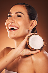 Image showing Skincare, coconut and woman in studio happy to promote fruit diet benefits, beauty cosmetics or facial treatment. Smile, young or healthy woman marketing or advertising coconut oil for a glowing face