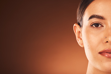 Image showing Skincare, half face portrait and woman with a wellness, health and natural facial routine in a studio with mockup space. Cosmetic, beauty and model with face treatment isolated by a brown background.