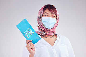 Image showing Covid, Muslim woman and mask for vaccine card, protection and healthy for wellness, happy and on grey studio background. Islam lady, face cover and vaccination proof for travel, safety and corona.