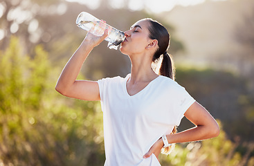 Image showing Drinking water, fitness and exercise woman after sports run and training in nature. Workout, hiking and walking challenge with a bottle of a female runner in summer ready for running for health