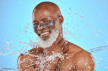 Image showing Skincare, water and portrait of black man with facial on blue background in studio for wellness, spa and cleanse. Cleaning, beauty and senior male with water splash, facial mask and luxury treatment