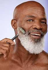 Image showing Skincare, face roller and senior black man in studio on purple background for wellness, beauty and grooming. Dermatology, cosmetics and elderly male with jade roller for facial massage and treatment