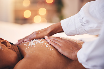 Image showing Spa, massage and salt on back for detox, exfoliate and skin care with hand of therapist for luxury treatment for health and wellness. Client on table to relax with body scrub cosmetic at beauty salon