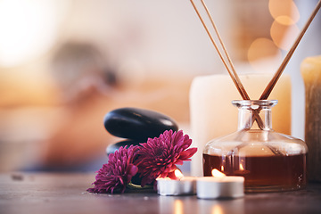 Image showing Hot stones, candles and aroma oils in relax spa, hotel salon or self care retreat for healthcare wellness, massage or luxury peace. Zoom, texture and incense scent on table in beauty or empty clinic