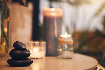 Image showing Stone, candle and spa with a still life objects on a table in a wellness center for aromatherapy to relax. Background, rock and luxury with stones and candles in a health salon for stress relief