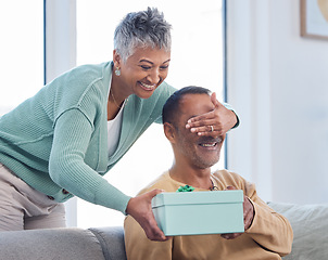 Image showing Senior couple, gift and surprise in home living room with wife covering eyes of husband. Love, care and retired elderly man receiving box of presents from woman for Christmas or birthday celebration.