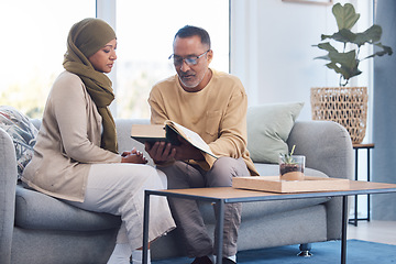 Image showing Worship, muslim and couple reading the quran for gratitude on sofa in their living room together. Islam, retirement and senior man and woman with a hijab studying the islamic religion during ramadan.
