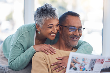 Image showing Love, senior couple and reading newspaper in living room of home. Retirement, relax and happy elderly man and woman embrace in house, hugging or cuddle while looking at news article or story in house