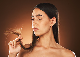 Image showing Beauty, woman and hair check for growth of split ends with worried, ponder and thinking face. Concerned skincare, body and hair care model with treatment problem on brown studio background.