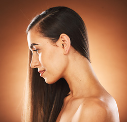 Image showing Face, beauty and hair with a model woman in studio on a brown background to promote keratin treatment. Haircare, hairstyle and wellness with an attractive young female posing for natural hair care