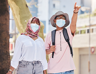 Image showing Covid, travel and tourism with a muslim couple pointing while sightseeing outdoor overseas or abroad. Tourist, mask and honeymoon with an islamic man and woman traveling in the corona virus pandemic