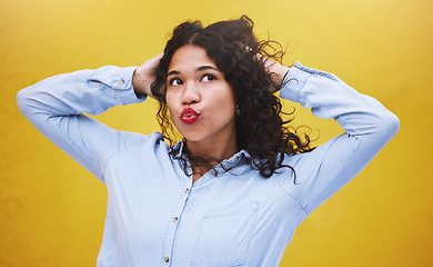 Image showing Freedom, beauty and youth, a black woman blowing a kiss or pouting with yellow background. Portrait of happy girl with hands in curly hair, kissing air. Fun, crazy and excited expression on female.