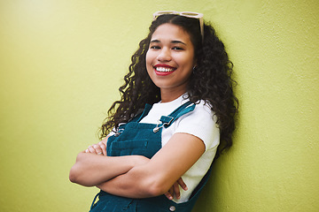 Image showing Girl smile with fashion glasses in hair, show expression of beauty, happiness and confidence. Portrait of beautiful latino woman, happy with arms crossed against green background or wall in the city