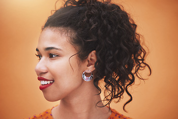 Image showing Face of happy young hispanic woman thinking of ideas, beauty and gen z fashion against an orange color studio background. Smile, youth and happiness of confident girl with curly hair, vision and joy