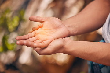 Image showing Hands, pain and active hand of a man hiking and suffering from a medical emergency outdoor. Healthcare, injury and fitness with a palm of a male highlighted with overlay and glow in nature