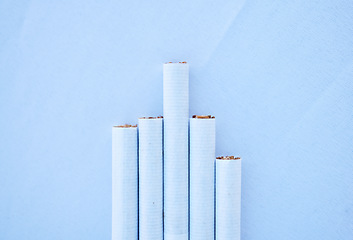 Image showing Cigarettes, table and mockup for healthcare habit, drug danger and lung cancer disease awareness on blue background. Zoom, tobacco smoke product and pack of smoking wellness safety on mock up texture