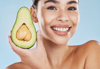 Image showing Avocado skincare, woman beauty and cosmetic wellness for healthy diet, happy results and clean glowing skin on blue background. Portrait, smile and young model face, grooming and fresh fruit bodycare