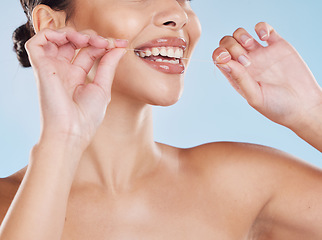 Image showing Woman flossing her teeth with dental floss for oral care, healthcare and hygiene in a studio. Girl with wellness, healthy and clean lifestyle doing her mouth routine for tooth and gum health.