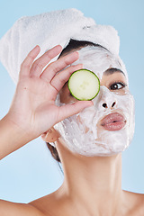 Image showing Beauty skincare, skin wellness and face mask with cucumber against a blue mockup studio background. Portrait of model pouting lips, vegetable for health and cosmetic person with healthy food