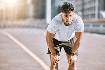 Image showing Man resting, after jogging and running in the city for fitness. Healthy, fit and alone runner catching his breath after a run in the morning. Training, cardio and relaxing after a workout in town.