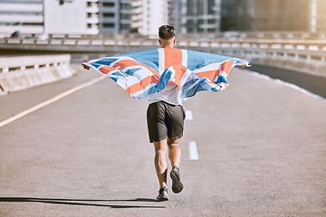 Image showing Winner, flag and fitness man running on the city road celebrates winning achievement in summer. Sports, training and competitive British male runner doing healthy exercise in celebration outside