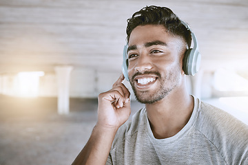 Image showing Workout music, fitness headphones or digital radio. Music technology device plays music, smiling relaxed indian man listening to audio sound earphone while exercising in city parking lot closeup.