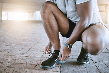 Image showing Shoes, running and sports with a man in training, workout and exercise for health, wellness and fitness in the city. Motivation with a runner tying his laces before a performance run for cardio