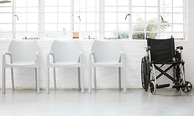 Image showing Diversity, inclusive and a row of white chairs with a black wheelchair in a waiting room in the hospital. Different empty seats in inside a lobby of a clinic or office corridor