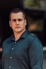 Image showing A portrait of a modern man, exuding confidence and style, against an outdoor backdrop, showcasing his charisma and fashionable demeanor.