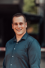 Image showing A portrait of a modern man, exuding confidence and style, against an outdoor backdrop, showcasing his charisma and fashionable demeanor.