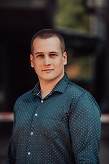 Image showing A portrait of a modern man, exuding confidence and style, against an outdoor backdrop, showcasing his charisma and fashionable demeanor.