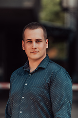 Image showing A portrait of a modern man, exuding confidence and style, against an outdoor backdrop, showcasing his charisma and fashionable demeanor.