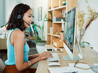 Image showing Working, typing and talking customer service support agent online helping a client on a computer. Female web help digital call centre employee with headset giving internet advice or tech assistance