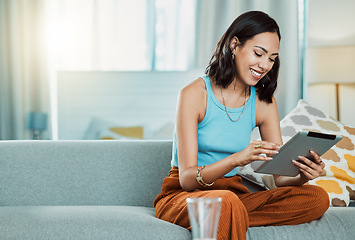 Image showing Streaming movies to watch online on digital tablet, watching videos and scrolling on social media while relaxing on the couch alone at home. Happy, smiling and casual female browsing the internet