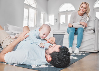 Image showing Care, bonding and parents with baby in the living room of their house. Playful, happy and mother and father with love for a child while playing with affection on the floor of the lounge as a family