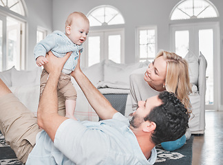 Image showing Relax, living room and parents playing with their baby together on the floor of their family home. Love, smile and happy mother and father bonding with their newborn child in the lounge of a house.