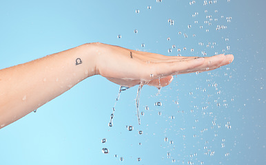 Image showing Woman cleaning hands with water splash, shower and beauty for healthy skincare, personal hygiene and wellness on blue background. Closeup of water drops for washing hands, palm and body in bathroom