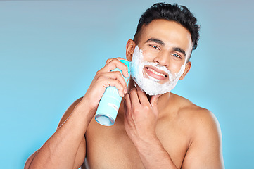 Image showing Skincare, face and man with shaving cream in studio on a blue background. Portrait, hair care or happy male model from Brazil spraying shave gel product for beard grooming, facial cleaning or hygiene