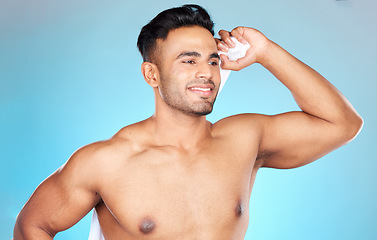 Image showing Man, towel and dry after shower, cleaning and wash with clean body, hygiene and bathroom in blue studio background. Skincare, wellness and model with happy smile for beauty,morning and cosmetic