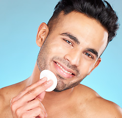 Image showing Cotton, skincare and man in studio for face glow, shine and beauty product promotion, marketing or advertising benefits. Happy portrait, skin care model and facial cleaning wipe in dermatology health