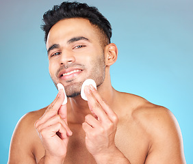 Image showing Man, skincare portrait and cotton pad in studio for beauty, wellness or cosmetic self care with smile. Happy, model face and cottonwool for cleaning, cosmetics or healthy aesthetic by blue background