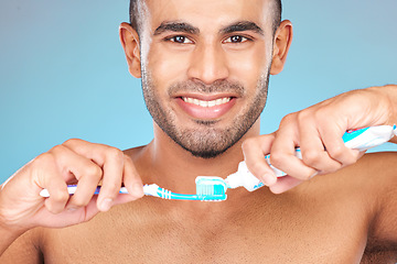 Image showing Portrait, man and brushing teeth with toothpaste, toothbrush and dental wellness for healthy lifestyle, cleaning or cosmetics on blue background in Turkey. Happy male model, oral mouth care and smile