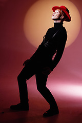 Image showing Man, fashion and pose of an aesthetic, stylish male model posing on a red studio background. Artistic, creative and trendy guy with fashionable or luxury clothing and confidence on a studio backdrop